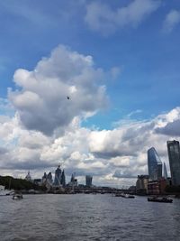 Sea by buildings against sky in city