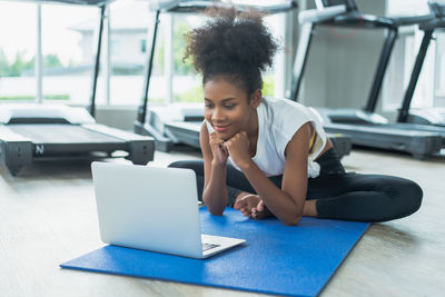 Young woman using laptop while sitting on table