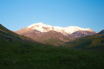 Scenic view of mountains against clear blue sky