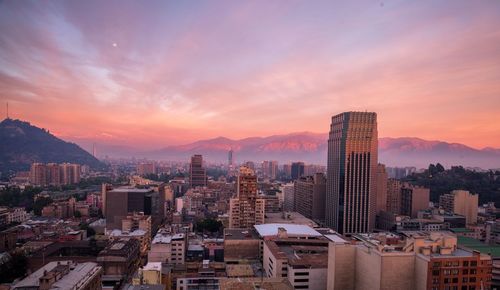 Aerial view of buildings in city against sky during sunset