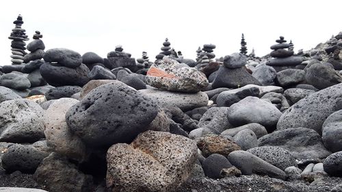 Stack of stones on beach against sky