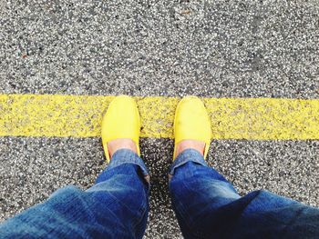 Low section of man standing on road