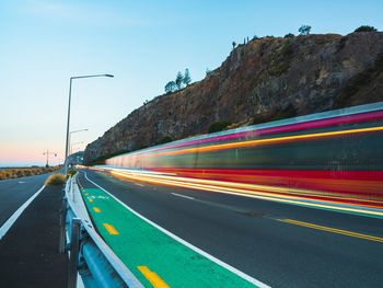 Light trails on road against sky