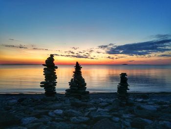 Scenic view of rocks in sea against sky during sunset