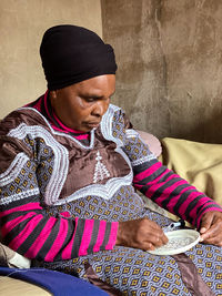 Midsection of a woman sitting against wall