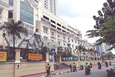 People on street amidst buildings in city