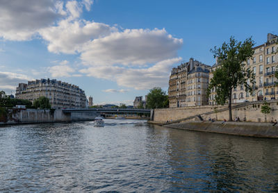 Bridge over river in city against sky