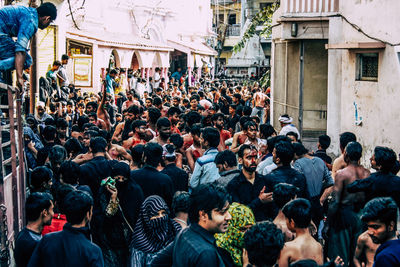 People walking on street against buildings in city