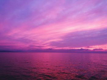 Scenic view of sea against dramatic sky during sunset