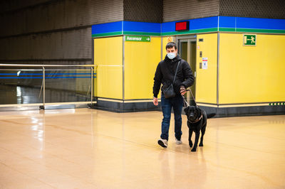 Blind man walking with guide dog in subway