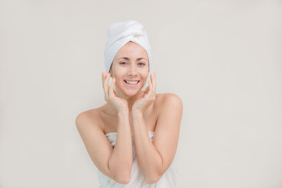 Portrait of a smiling young woman against white background