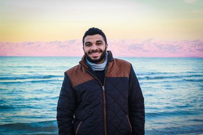 Portrait of happy man against sea during sunset