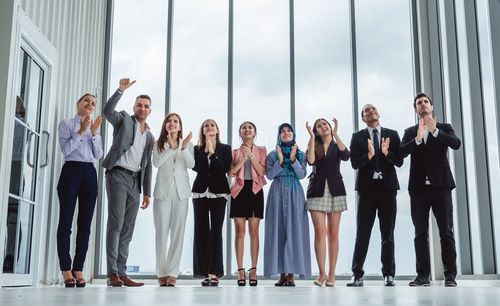 Business people clapping while standing in office