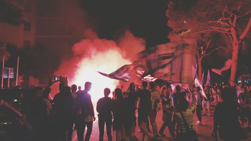 Fans on street with bonfire at night