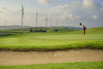 Full length of man on golf course against sky