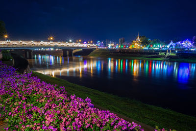 View of illuminated city at riverbank