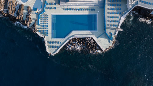 Aerial view of swimming pool on building by sea