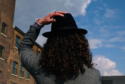 Rear view of woman wearing black  hat against sky