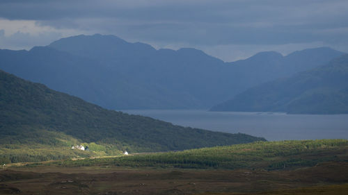 Scenic view of field and mountains against sky