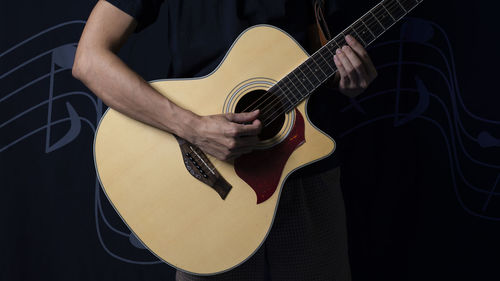 Midsection of man playing guitar