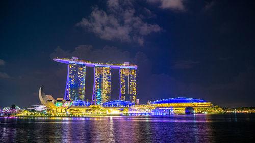 Illuminated bridge over river at night