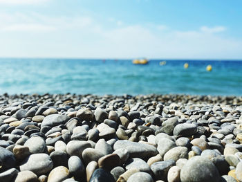 Surface level of pebbles on beach against sky