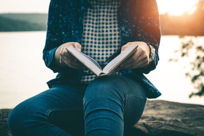 Midsection of woman reading book