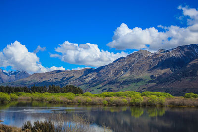 Scenic view of lake and mountains against sky