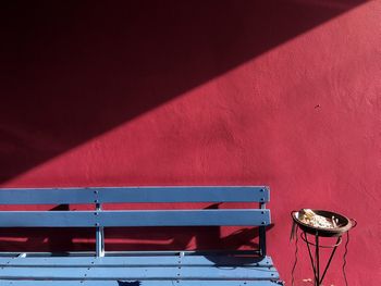 Red boat moored in water against wall