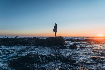 Woman standing at calm sea