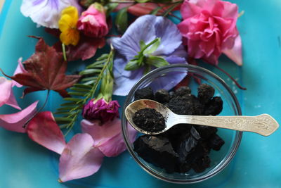 Close-up of coal by colorful flowers on table