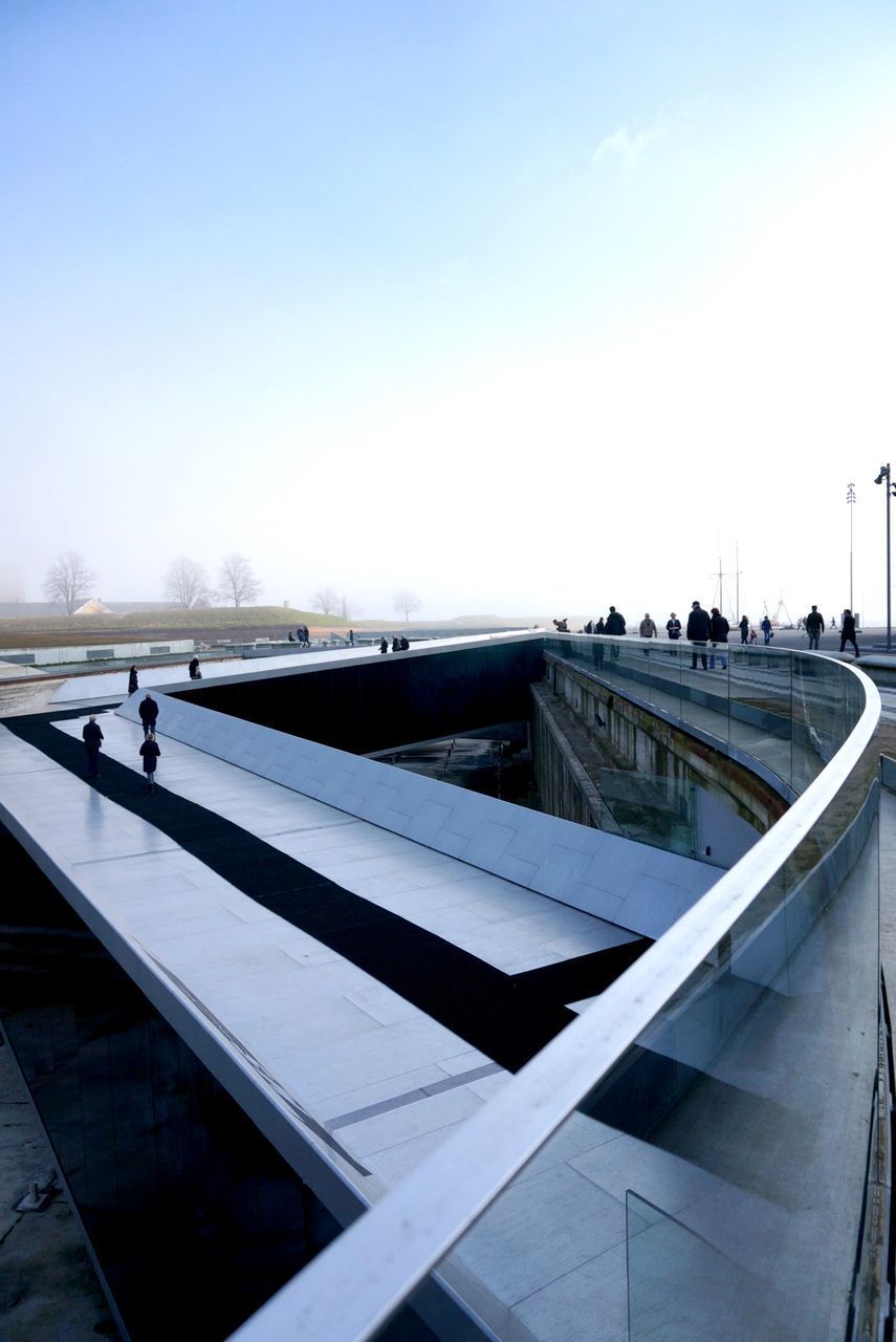 PEOPLE WALKING ON RUNWAY AGAINST SKY