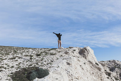 Full length of woman standing on cliff
