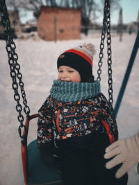 Rear view of boy swinging at playground