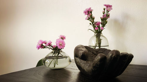 Flower vase on table against wall