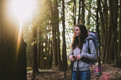 Young woman standing in forest