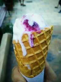 Close-up of hand holding ice cream cone