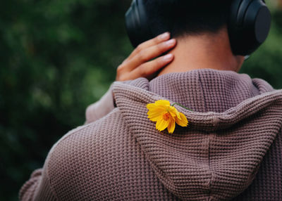 Midsection of man with yellow flower