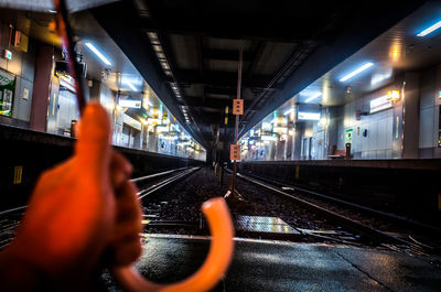 Man train at railroad station platform at night