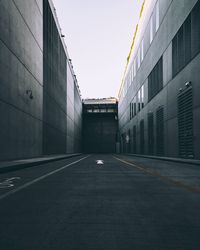 Empty road amidst buildings against clear sky