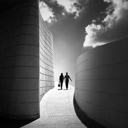 Full length rear view of woman walking on road