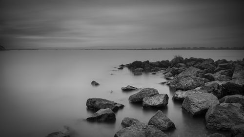 Rocks by sea against sky