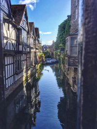 Canal amidst buildings against sky