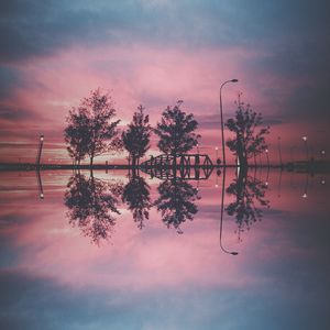 Low angle view of trees against cloudy sky