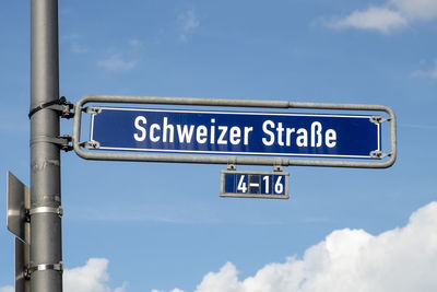 Low angle view of road sign against sky