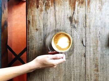 Directly above shot of hand holding coffee cup