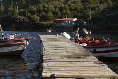 Boats moored on pier at lake