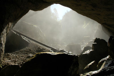 Cave entrance view form inside. exploring misty underground