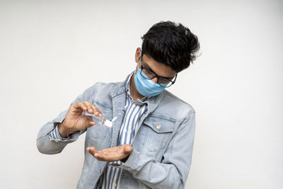 Young man looking away against white background