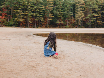 Girl playing by lake on a lovely autumn or fall day